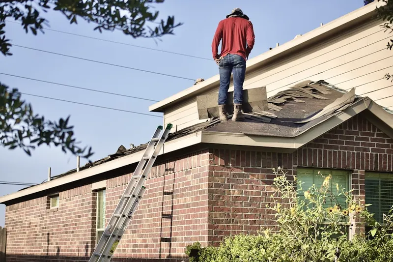 Professional roofer working on a residential roof in Fulton Mall